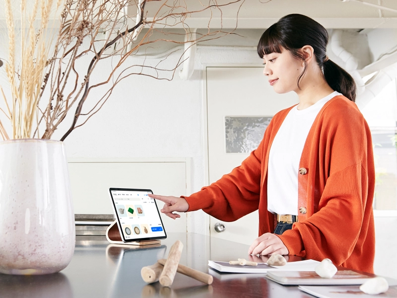 カウンターで従業員が会計をタブレットでおこなっている小売店の写真
